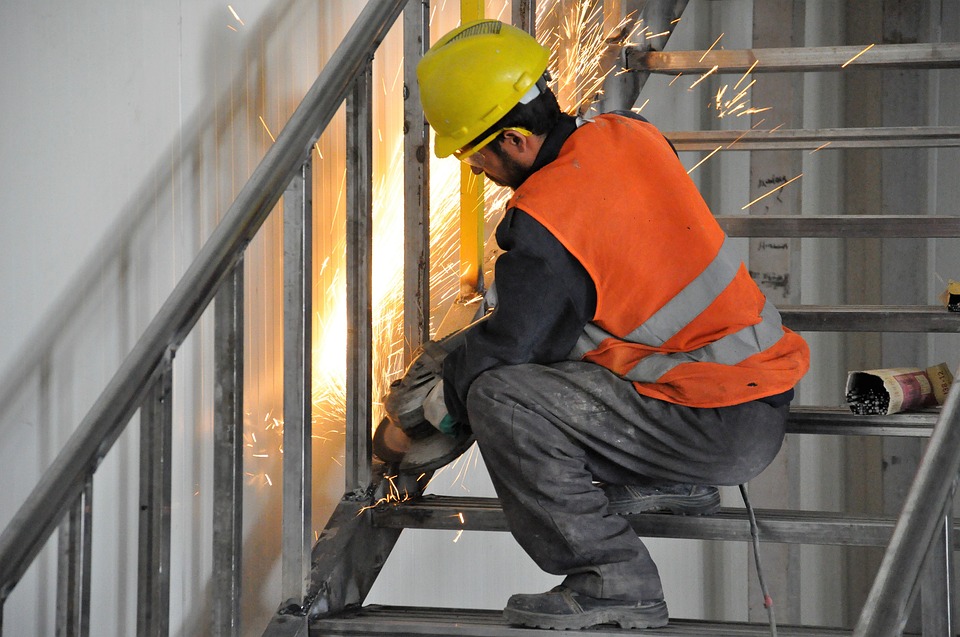 Lavoratore metallurgico che lavora sulle scale